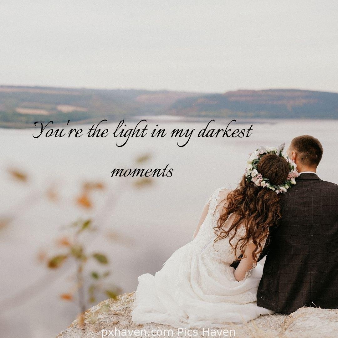 You're the light in my darkest moments. A girl and boy talking and and sitting together leaning on each other. The girl is wearing a white wedding dress and the boy is wearing a wedding suit. love romantic couple images and quotes. Love Quotes and Images for Couples. HD images. Free download.
