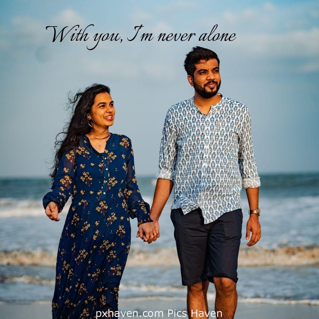 With you I am never alone. A girl and boy talking and walking by the sea holding hands in relationship and love. romantic couple images and quotes. Love Quotes and Images for Couples. HD images. Free download.