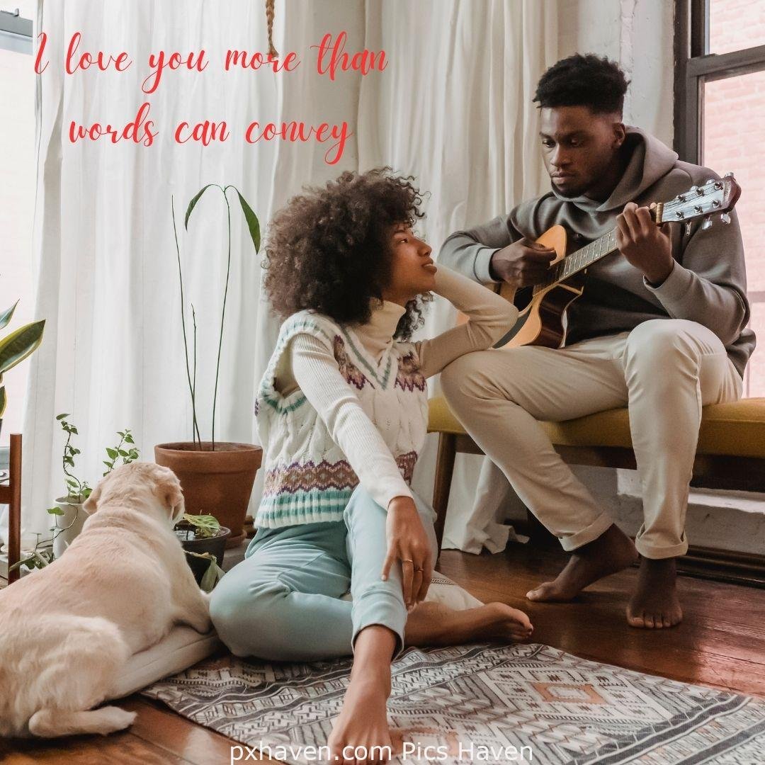 I love you more than words can convey. A boy and girl, sitting and playing guitar looking at each in the room. Love Quotes and Images for Couples. HD images. Free download.