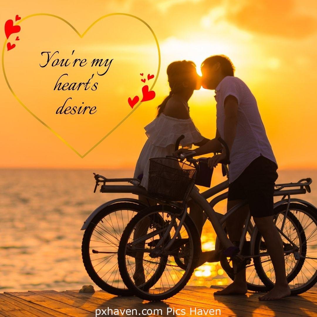 You're my heart's desire. A boy and girl kissing, standing with bicycles in relationship and love. romantic couple images and quotes. Love Quotes and Images for Couples. HD images. Free download.