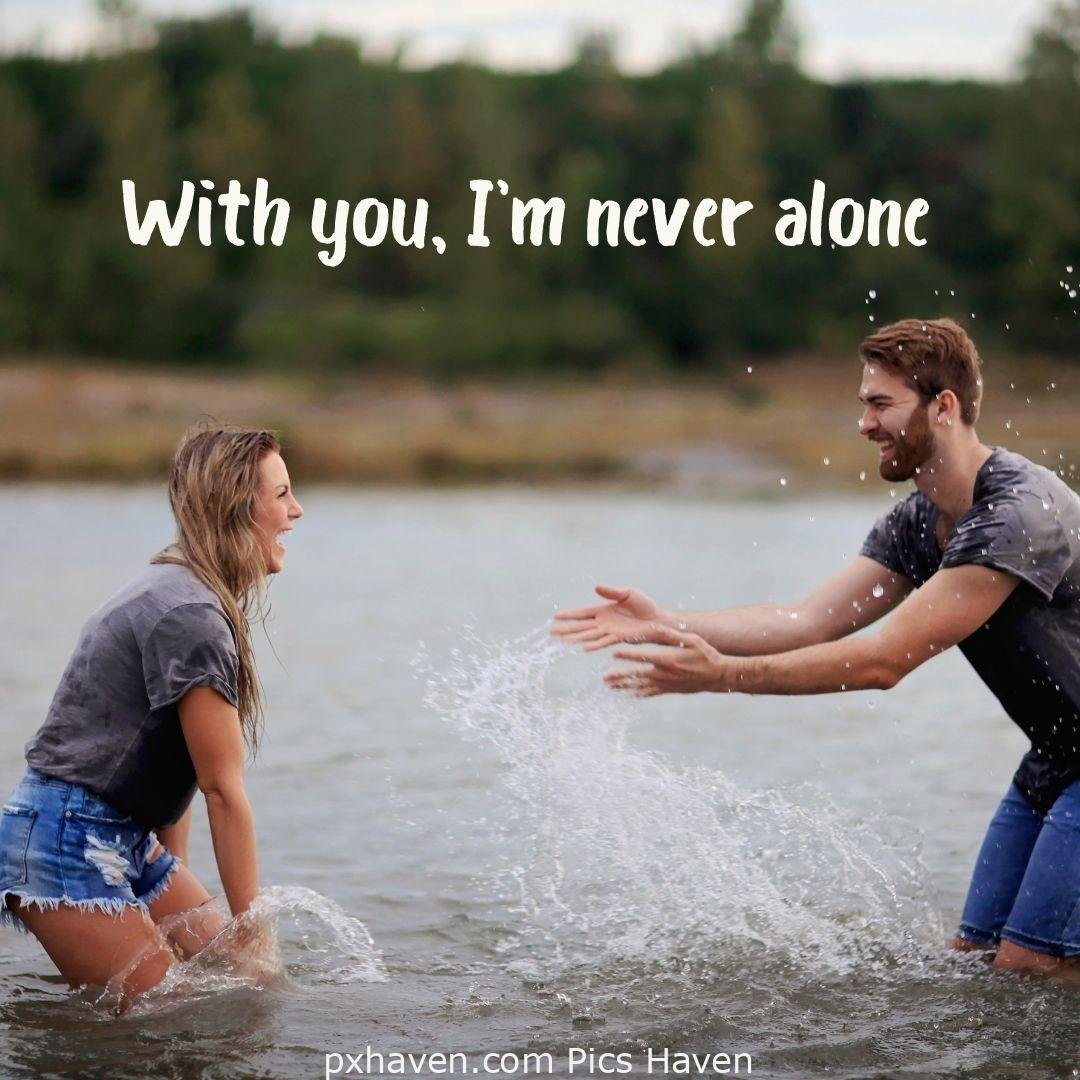With you I'm never alone. Aboy and girl playing in water talking and smiling and laughing together in relationship and love. romantic couple images and quotes. Love Quotes and Images for Couples. HD images. Free download.
